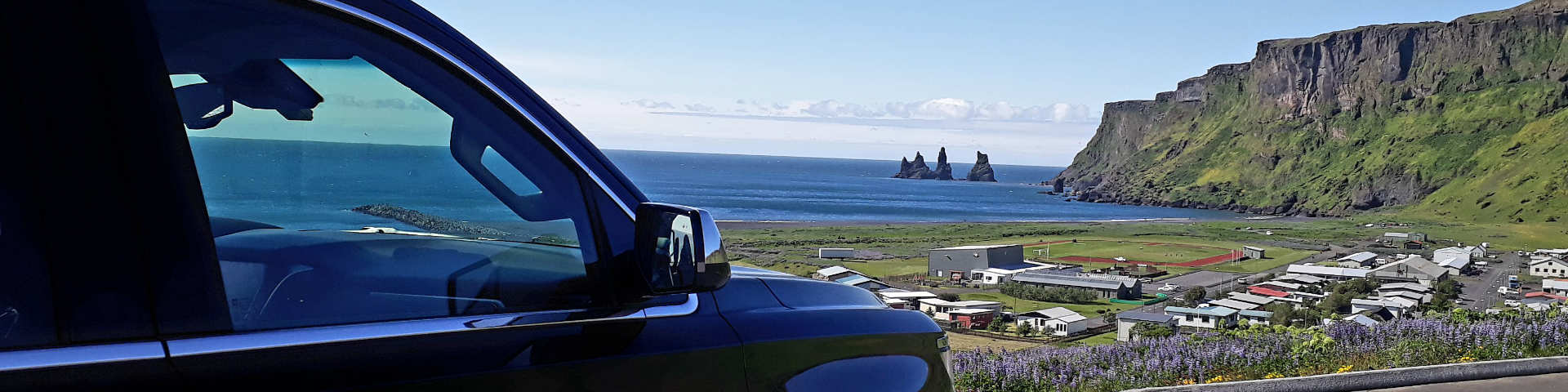 Black Suburban in Vík í Mýrdal view of Reynisdrangar